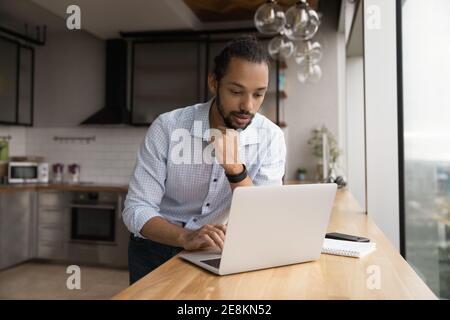 Focused biracial man student contact friend using messenger pc app Stock Photo