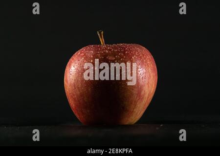 red apple on black background and water droplets on it Stock Photo