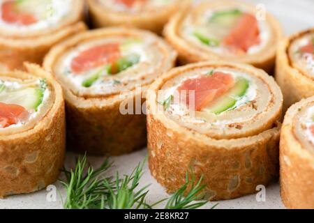 Salmon, cucumber and cream cheese crepe rolls. Appetizer finger food closeup view Stock Photo