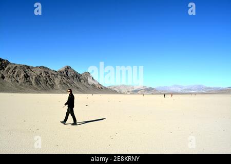 single person standing on the Racetrack Playa in the Death Valley National Park - one man exploration the sailing stones, a phenomenon in the desert, Stock Photo