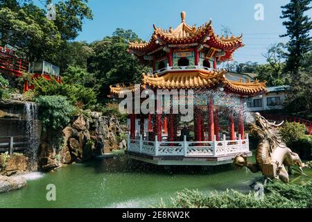 Golden dragon water fountain statue with pond and buddhist gazebo in Taipei Taiwan. Stock Photo