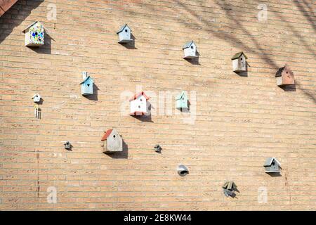 Large number of bird houses on the wall of a house Stock Photo