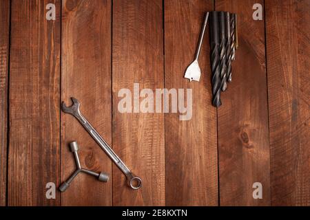Keys, screwdrivers on a wooden brown background. Empty space for text. Stock Photo