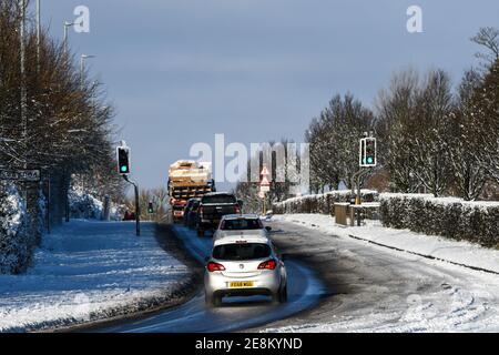 vehicles travelling after heavy snowfall on epinal way loughborough Stock Photo