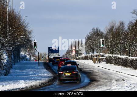 vehicles travelling after heavy snowfall on epinal way loughborough Stock Photo