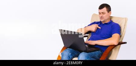 Banner,long format. A man in a leather armchair communicates using gestures online via a laptop. White background and lots of white space for Stock Photo