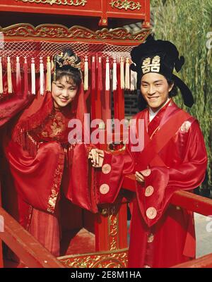 China, Beijing, Traditional Wedding Ceremony, Man and Women Dressed in Traditional Wedding Costume Stock Photo
