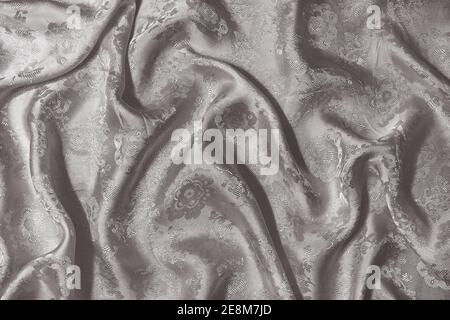 Background with the texture of gray silk fabric draped with pleats. Stock Photo