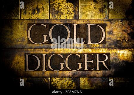 Gold Digger text on vintage textured grunge copper and gold background Stock Photo