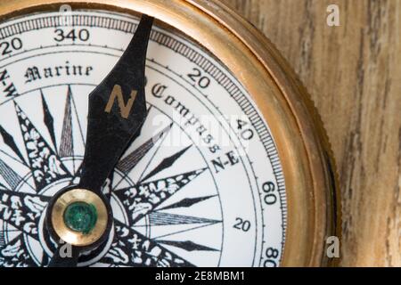 Old Fashioned compass pointing to north on a wooden deck plank Stock Photo