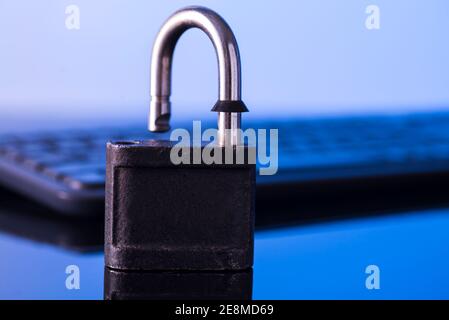 Locking the computer keyboard. The lock and keypad are tinted blue. Information security concept. Stock Photo
