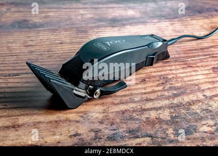 Norwich, Norfolk, UK – December 19 2020. An illustrative photo of a set of Wahl 100 electric hair clippers on a wooden floor Stock Photo