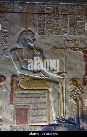 Bas relief carving of the ancient Egyptian god Amun. Coloured blue with a headdress of ostrich feathers. Wall of Abydos Temple, near el Balyana, Egypt Stock Photo
