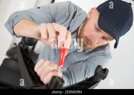 man assembles new office chair Stock Photo
