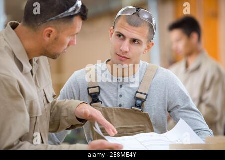 workers with paper in factory Stock Photo