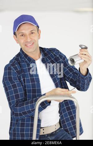 happy contractor installing surveillance cctv cameras Stock Photo