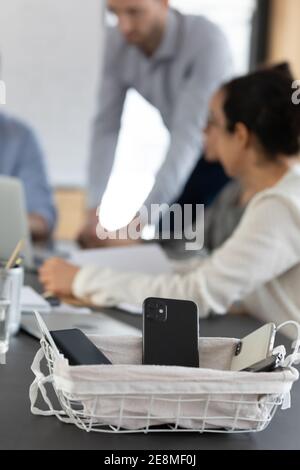 Free of cellphones area. Close up container with mobile phones Stock Photo