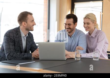 Happy married clients consulting real estate agent in his office Stock Photo