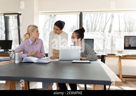 Friendly Indian female mentor training interns, working with new employees Stock Photo