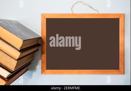 Chalkboard for your text and a stack of books. Distance education concept, course announcement. Stock Photo