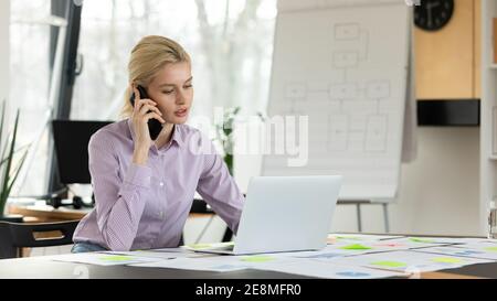 Young female entrepreneur working in office alone Stock Photo