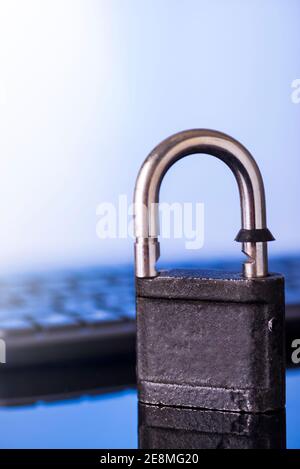 Locking the computer keyboard. The lock and keypad are tinted blue. Information security concept. Stock Photo