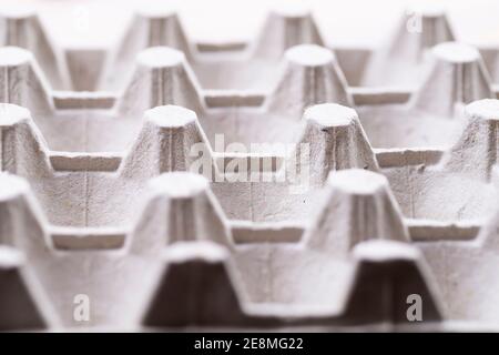 Cardboard box for raw eggs close-up. Gray egg carton. Recycling paper container for packing raw eggs. Packing material. Egg crate. Stock Photo