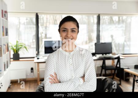 Confident Indian millennial businesswoman posing with hands folded Stock Photo