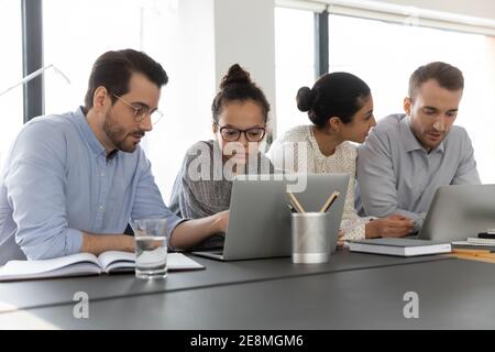 Employees working at computer together, discussing content Stock Photo