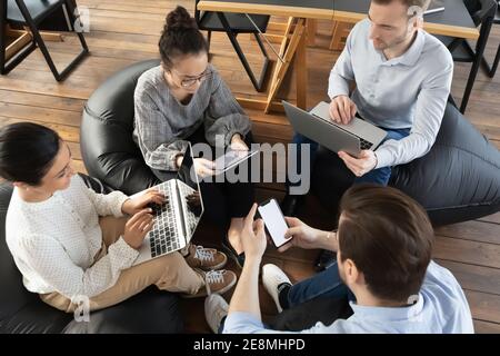 Office colleagues using digital devices during meeting, consulting internet Stock Photo