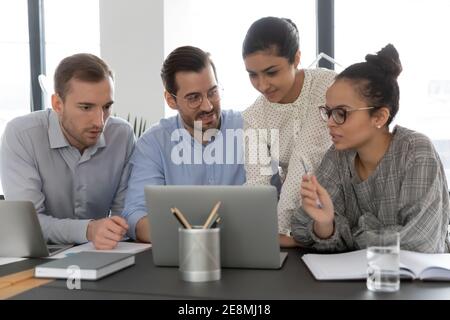 Diverse office people meeting and using shared laptop Stock Photo