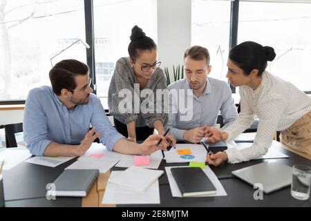 Multiethnic team of colleagues brainstorming over documents Stock Photo