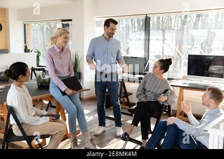 Business coaches teaching diverse team of interns Stock Photo