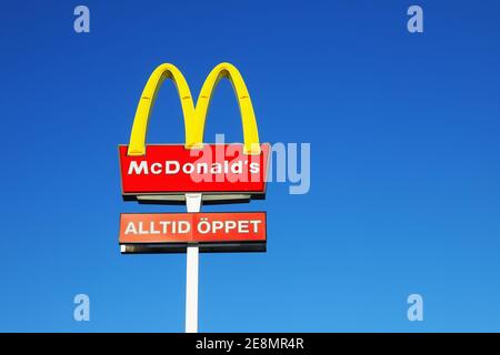 Sodertalje, Sweden - January 31, 2021: The McDonalds sign outside the hamburger restaurant with an additional sign allways open in Swedish against a b Stock Photo