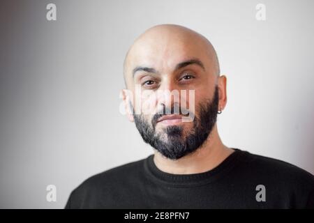 Close-up portrait of a bearded bald man. White background Stock Photo