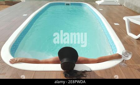 Mulher relaxando na piscina no verão Stock Photo