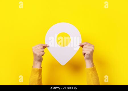 white map pointer 3d pin  in hand over yellow background Stock Photo