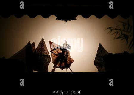 Indonesian puppet called wayang kulit performing on screen at night Stock Photo