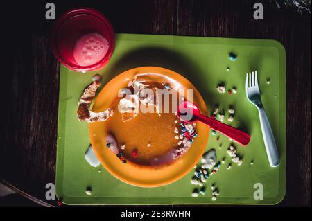 Children can be messy eaters - typical arrangement after eating. Stock Photo