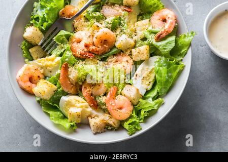Shrimp Salad. Seafood Caesar Salad on gray stone background close up. Stock Photo