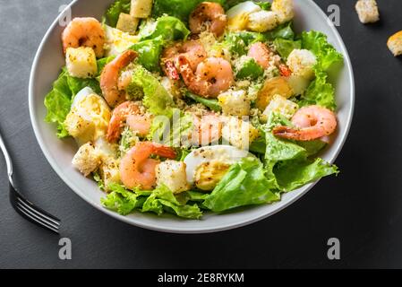 Shrimp Salad. Seafood Caesar Salad on black background, close up. Stock Photo