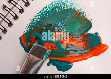 Brush when mixing paint on paper, macro shot Stock Photo