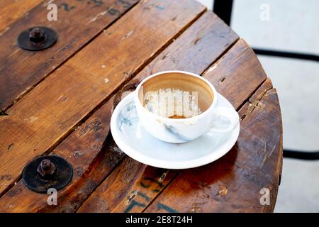 Dirty empty coffee mug cups containing coffee on wooden table in Banquet hotel buffet business. Stock Photo