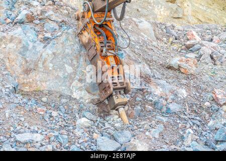 Bulldozer equip with drill, breaking down a hill landscape for homes and buildings. Stock Photo