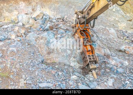 Bulldozer equip with drill, breaking down a hill landscape for homes and buildings. Stock Photo