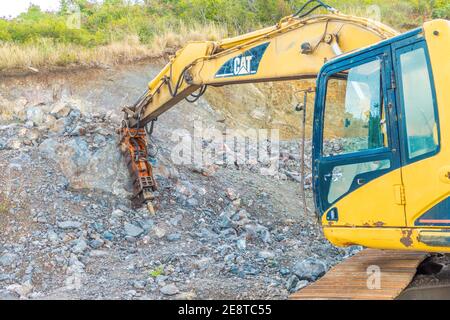 Bulldozer equip with drill, breaking down a hill landscape for homes and buildings. Stock Photo