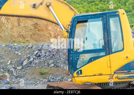 Bulldozer equip with drill, breaking down a hill landscape for homes and buildings. Stock Photo