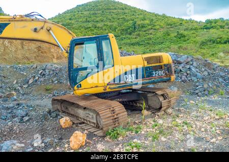 Bulldozer equip with drill, breaking down a hill landscape for homes and buildings. Stock Photo