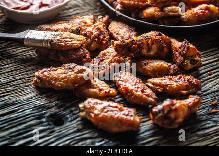 Chicken wings barbeque in a cast iron baking dish with BBQ sauce Stock Photo