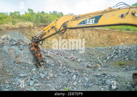 Bulldozer equip with drill, breaking down a hill landscape for homes and buildings. Stock Photo